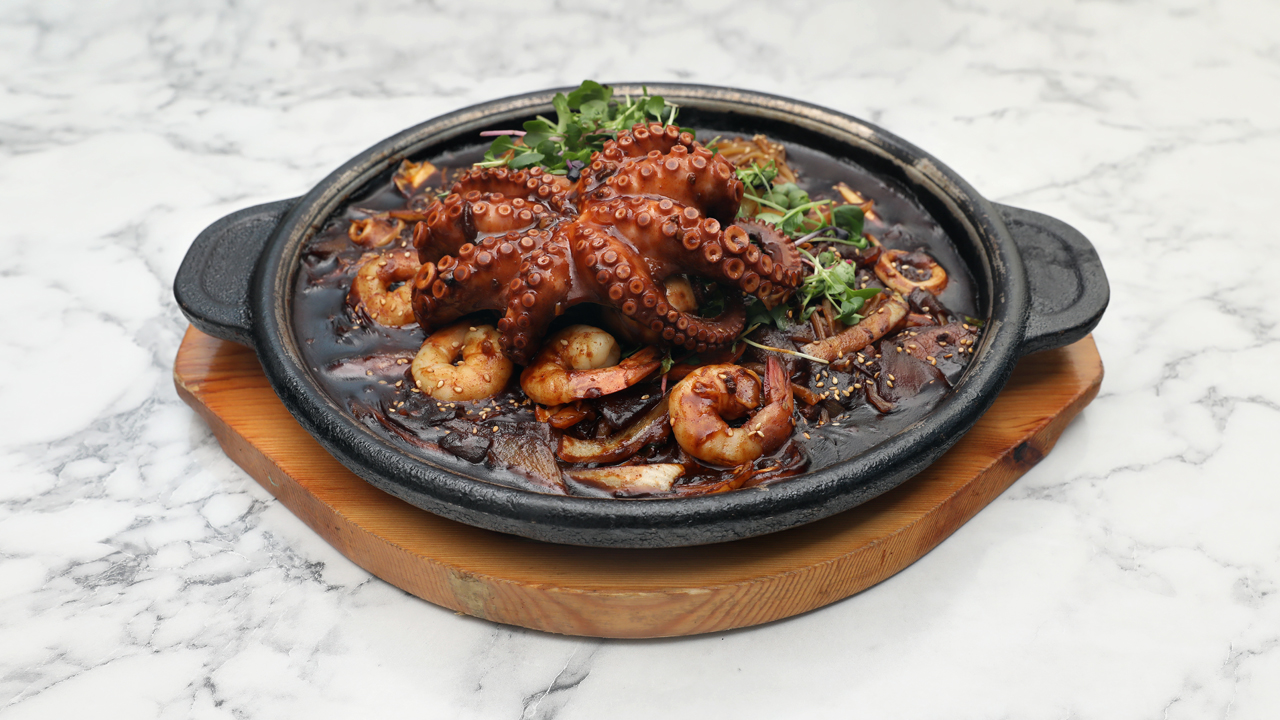 Fideos en salsa de judías negras con pulpo en plato de piedra 1